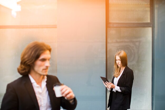 Femme utilisant une tablette avec un homme flou