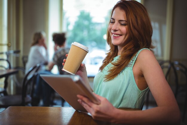 Femme utilisant tablette numérique dans le café