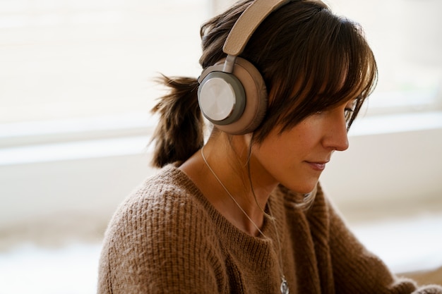 Femme utilisant la technologie des écouteurs sans fil