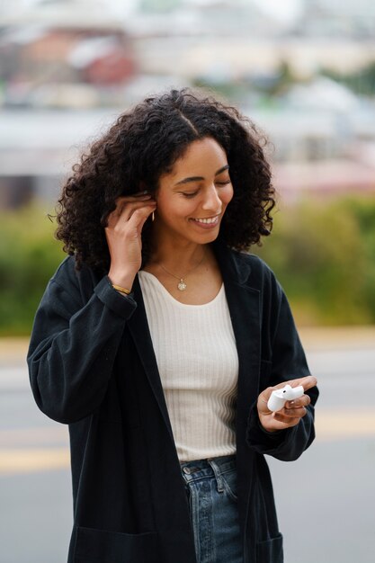 Femme utilisant la technologie des écouteurs sans fil