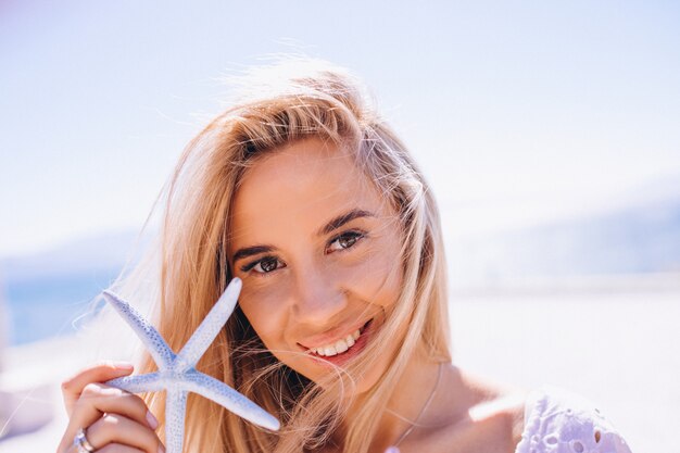 Femme en vacances tenant une étoile de mer