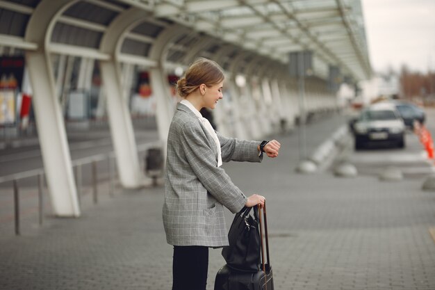 Femme, valise, debout, aéroport