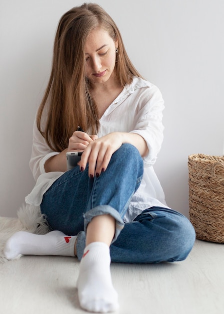 Femme à venir avec de nouvelles idées pour un blog sur le sol