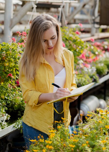 Femme vérifiant les besoins de l'agenda de la serre