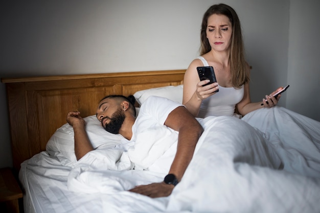 Photo gratuite femme vérifiant le téléphone de son petit ami pendant son sommeil