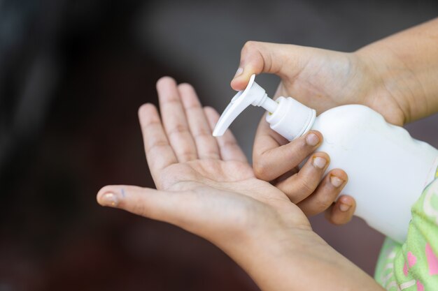 Femme versant du savon dans sa main à partir d'une bouteille de presse à main