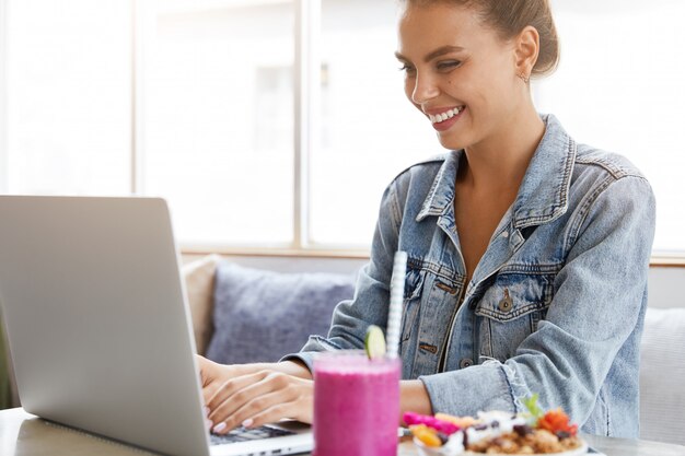 Femme en veste en jean élégante dans un café