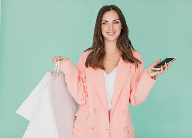 Photo gratuite femme en veste rose souriant à la caméra