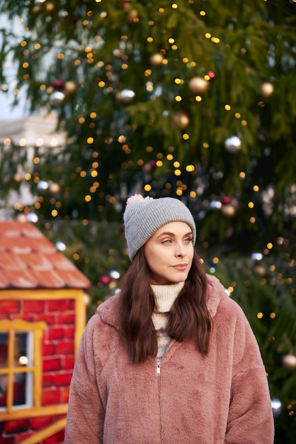 Femme en vêtements chauds sur le marché de Noël