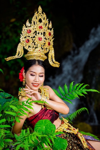 Une femme vêtue d&#39;une ancienne robe thaïlandaise à la cascade.