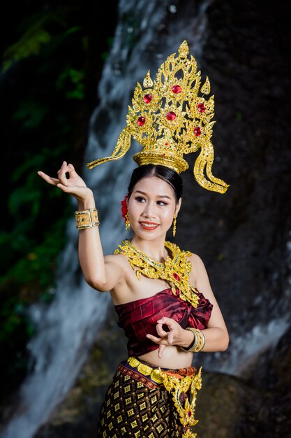 Une femme vêtue d&#39;une ancienne robe thaïlandaise à la cascade.