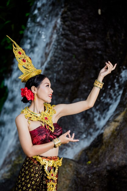 Une femme vêtue d&#39;une ancienne robe thaïlandaise à la cascade.