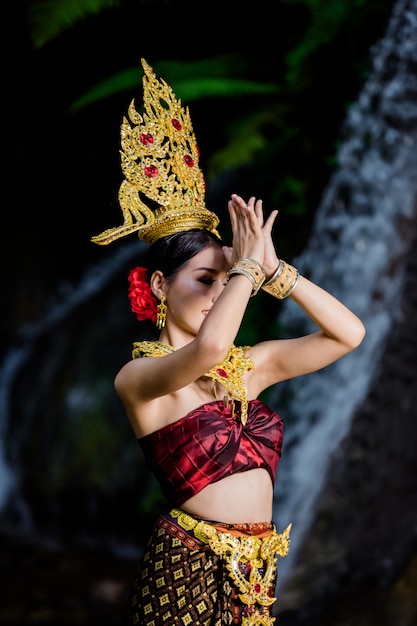 Une Femme Vêtue D'une Ancienne Robe Thaïlandaise à La Cascade.