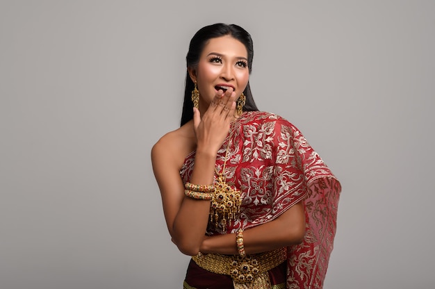 Photo gratuite femme vêtue d'une robe thaïlandaise faite d'un symbole de la main