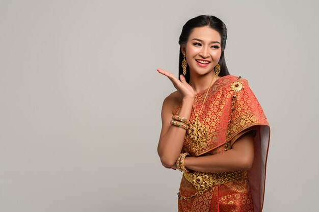 Photo gratuite femme vêtue d'une robe thaïlandaise faite d'un symbole de la main