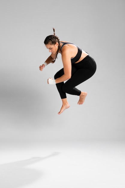 Femme vêtue de vêtements de fitness sautant