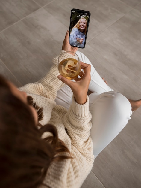 Femme vidéo appelant des amis en quarantaine avec boisson