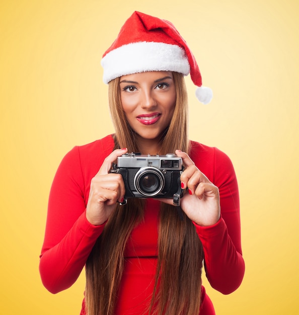 Femme avec un vieil appareil photo dans un fond jaune