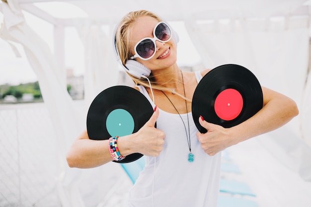 Femme avec vinyle gesticulant pouce en l&#39;air