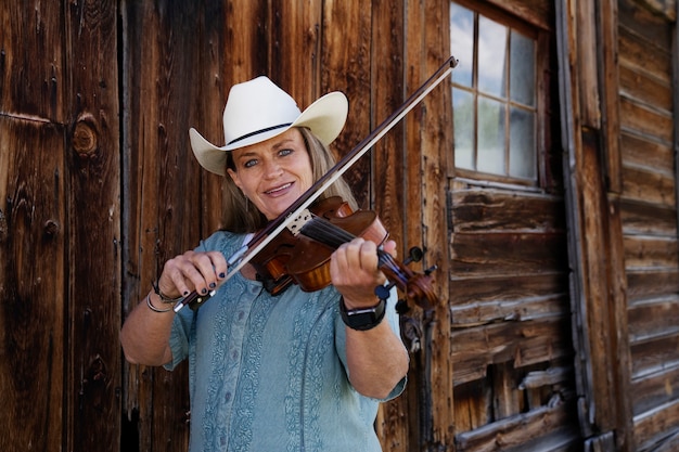 Photo gratuite femme avec violine se prépare pour un concert de musique country