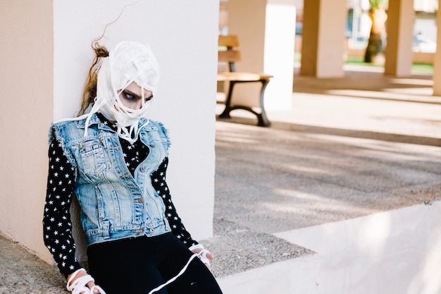 Femme avec visage bandé sur la rue