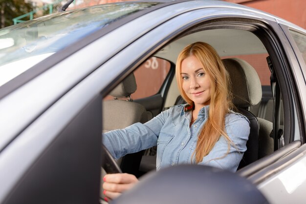 Femme en voiture avec coussin de siège de massage