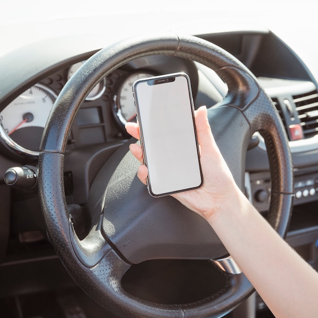 Femme en voiture en regardant un modèle de smartphone