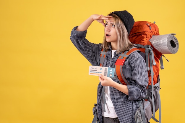 femme voyageur avec sac à dos tenant un billet en levant