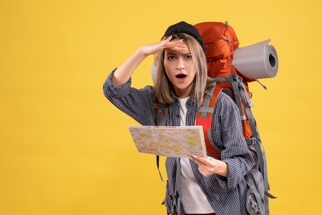 femme voyageur avec sac à dos tenant une carte regardant la caméra