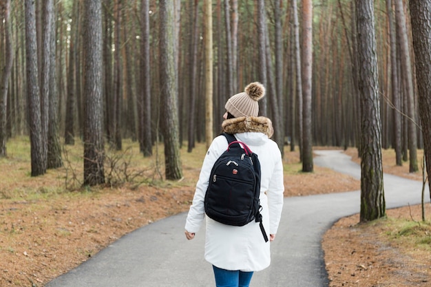 Femme vue arrière marchant dans la forêt