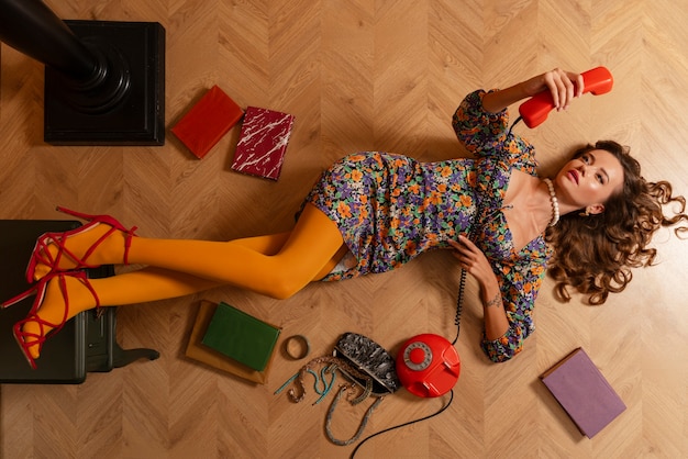 Femme vue de dessus posant avec un vieux téléphone