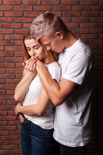 Femme vue de face embrassant la main de son copain