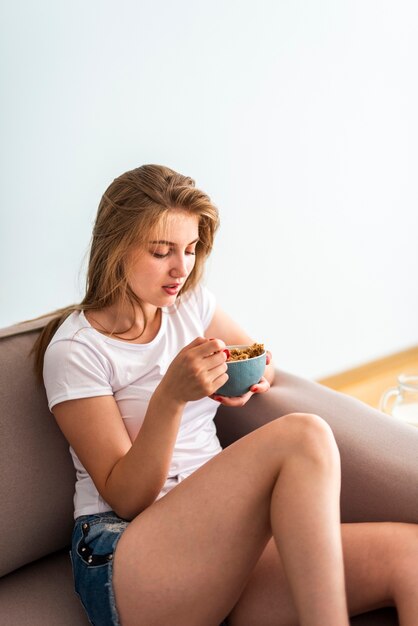 Femme vue de face manger des céréales