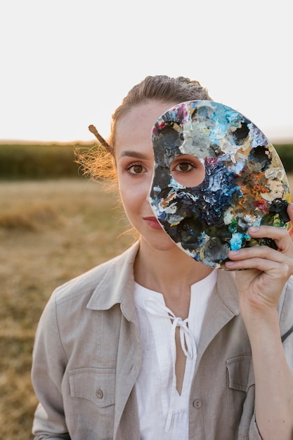 Femme vue de face avec palette de peinture