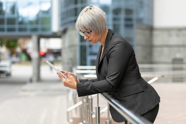 Femme vue de face en plein air à la recherche sur une tablette