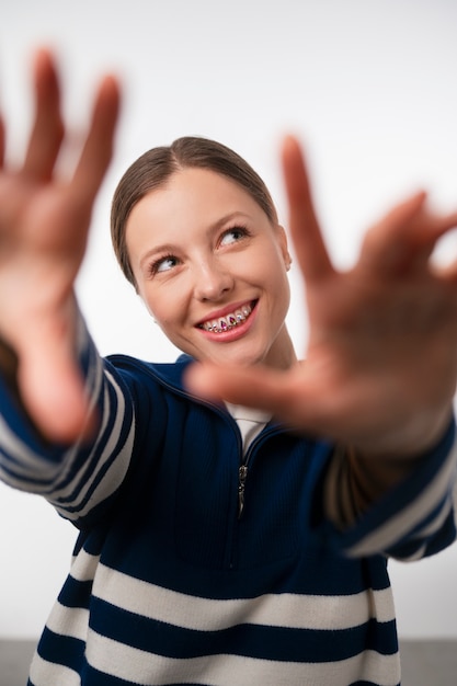 Femme vue de face posant avec des pierres précieuses dentaires