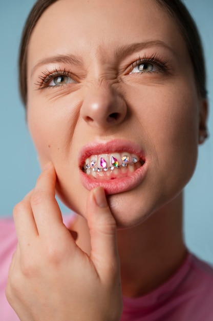 Photo gratuite femme vue de face posant avec des pierres précieuses dentaires