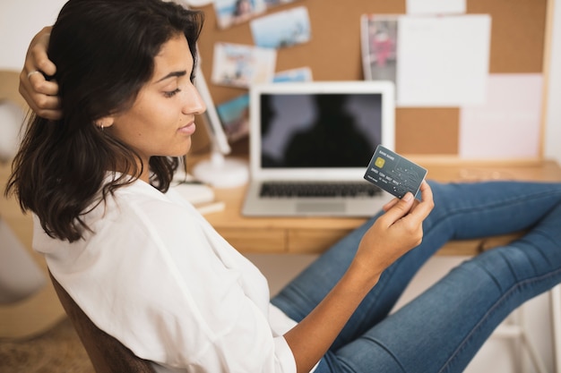 Femme vue de face en regardant une carte de crédit