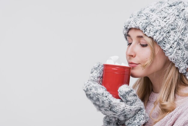 Femme vue de face avec une tasse rouge