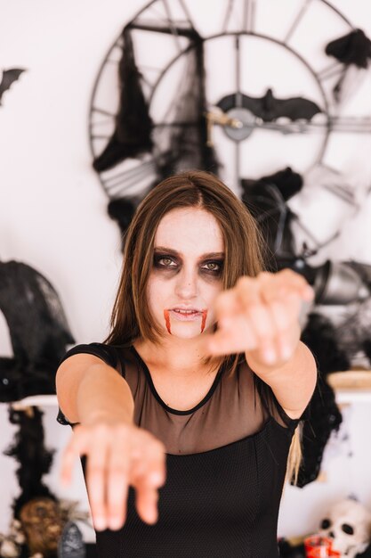 Femme avec zombie d&#39;Halloween sombre devant un mur avec des chauves-souris