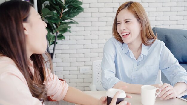 Femmes d&#39;affaires asiatiques profitant de boire du café chaud, discuter de travail et bavarder