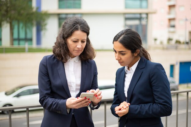 Femmes d'affaires ciblées utilisant un smartphone