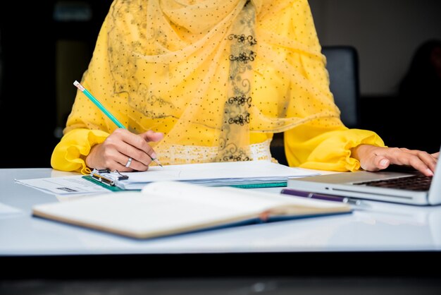 Les femmes d'affaires musulmanes écrivent et signent sur le papier.