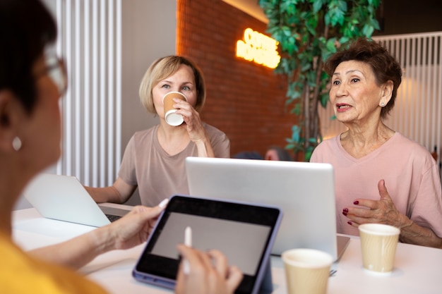Femmes âgées passant du temps ensemble à travailler sur un ordinateur portable