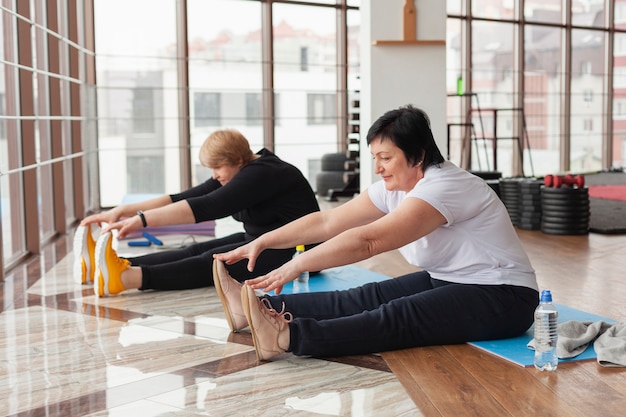 Femmes aînées, à, gymnase, étirage