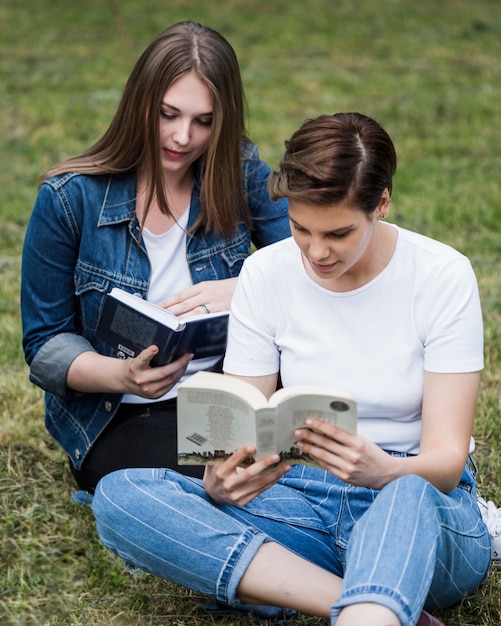 Femmes amis lisant dans le parc