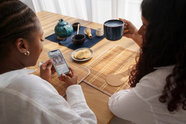 Femmes à angle élevé appréciant le matcha bleu à la maison