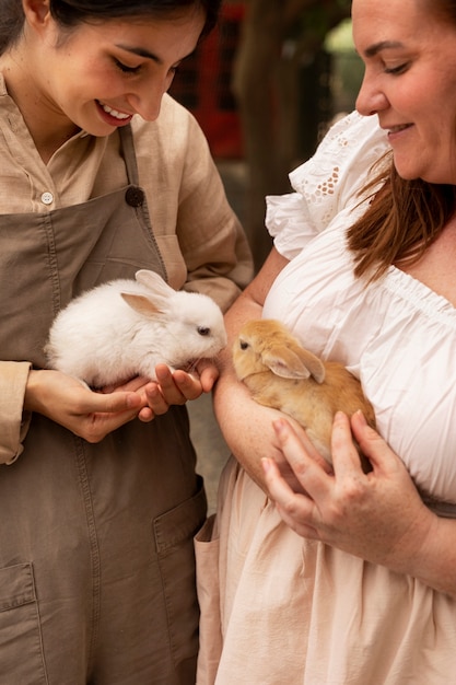 Femmes à angle élevé tenant des lapins mignons