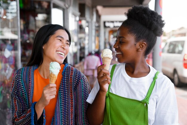 Photo gratuite femmes appréciant la crème glacée à l'extérieur