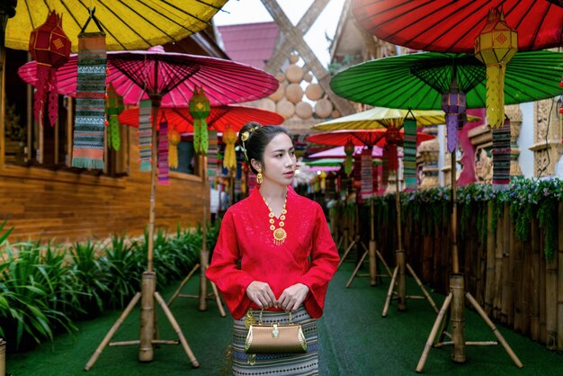 Les femmes asiatiques portant des costumes traditionnels thaïlandais selon la culture thaïlandaise à un endroit célèbre dans la province de Nan, Thaïlande. Traduction: "bienvenue"